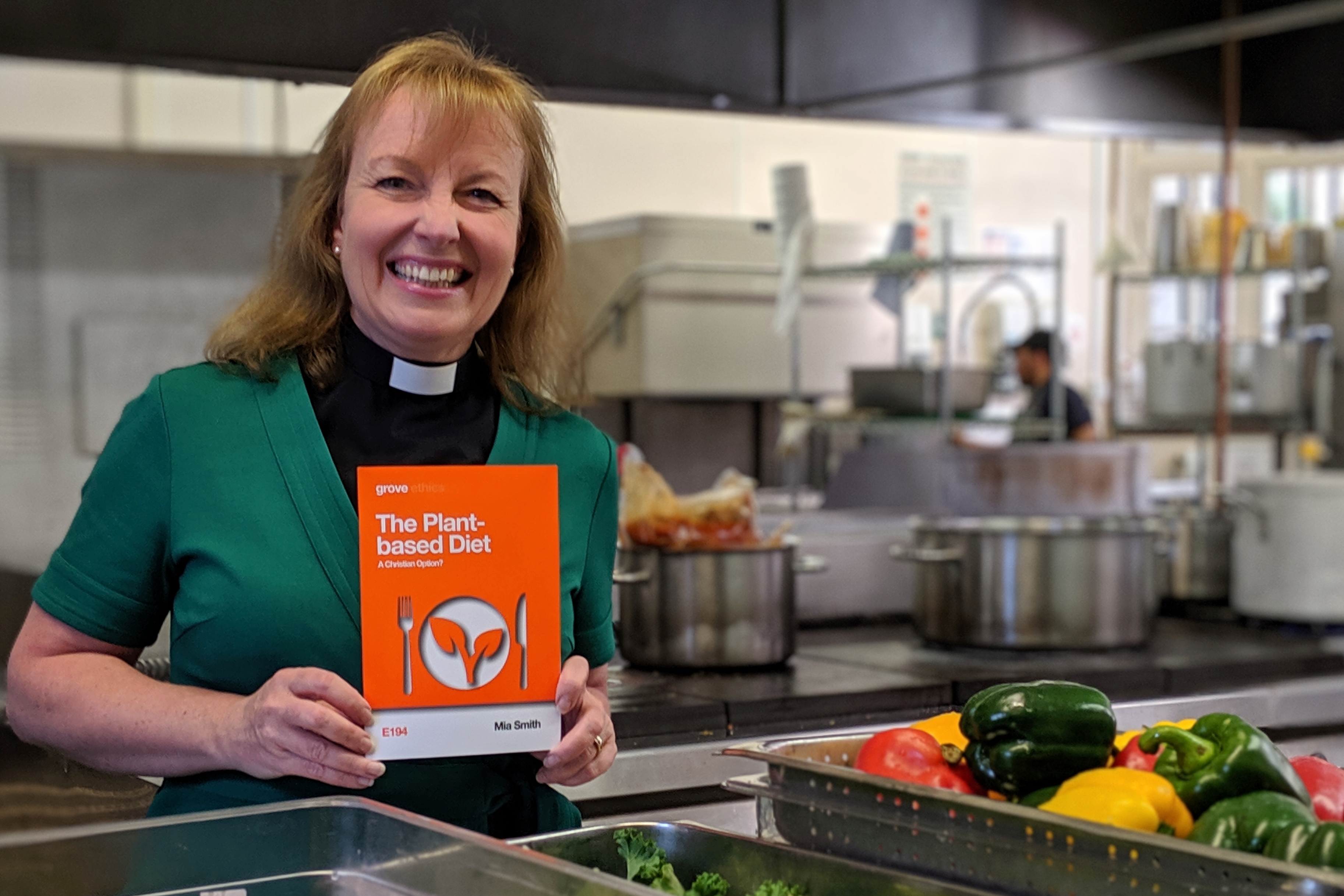 Mia holding her book in the kitchen